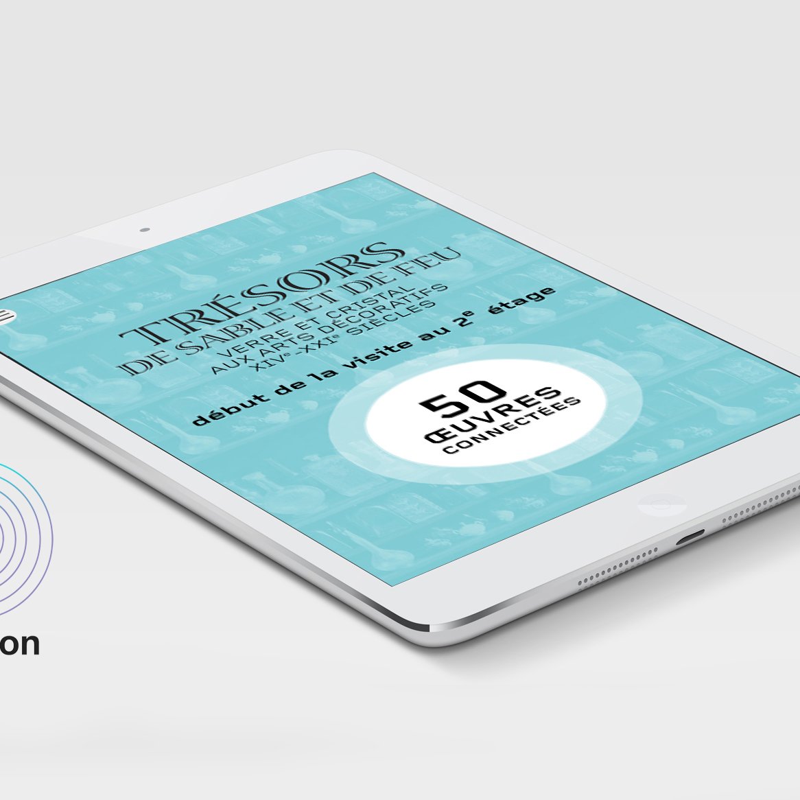 L'image montre une tablette affichant un écran qui annonce une exposition intitulée "Trésors de sable et d'eau". Le fond est de couleur turquoise, et le texte met en avant le début d'une visite à deux étages avec une mention de "50 œuvres connectées". À gauche, il y a un logo iBeacon, qui est généralement utilisé pour la localisation ou l'interaction via des dispositifs mobiles. Le design est moderne et attrayant.