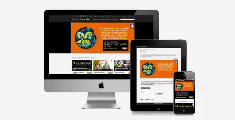 L'image montre une interface de site web affichée sur plusieurs appareils : un ordinateur de bureau, une tablette et un smartphone. Le site semble promouvoir des festivals de musique, avec un accent sur un événement particulier, affichant un design coloré et attirant. On peut apercevoir du texte et des images qui mettent en avant divers contenus liés à la musique.